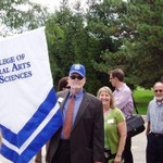 Dean and faculty with the banner